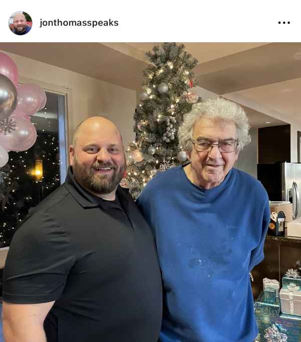 Photo of Jon Thomas with an older gentleman at Christmas.